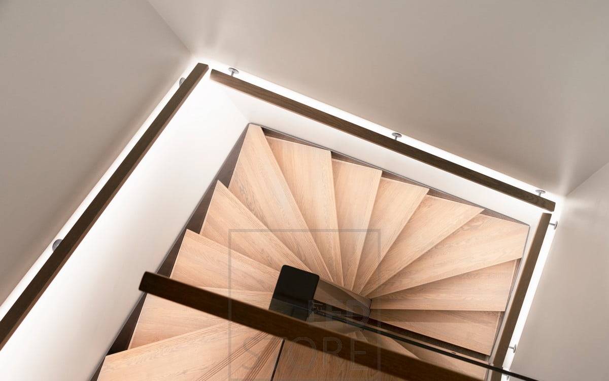 Eclairage d'ambiance indirect de l'escalier avec une bande LED sur la main courante. Les marches de l'escalier sont éclairées de manière uniforme mais douce.